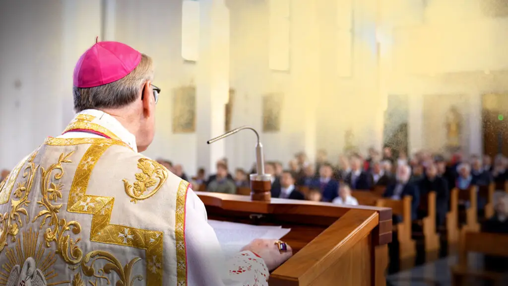 Dieses Bild zeigt Bischof Vitus Huonder während einer Predigt am Fest Allerheiligen in der Kirche St. Karl Borromäus der Priesterbruderschaft St. Pius X in Oberriet. Im Hintergrund sitzen viele Gläubige in den Kirchenbänken.