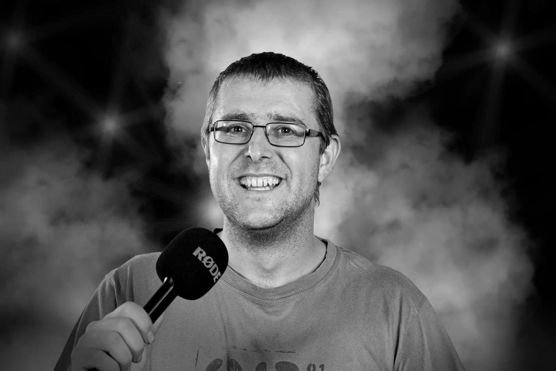 Solist Marty beim Singen auf einer Bühne mit Rauch im Hintergrund.