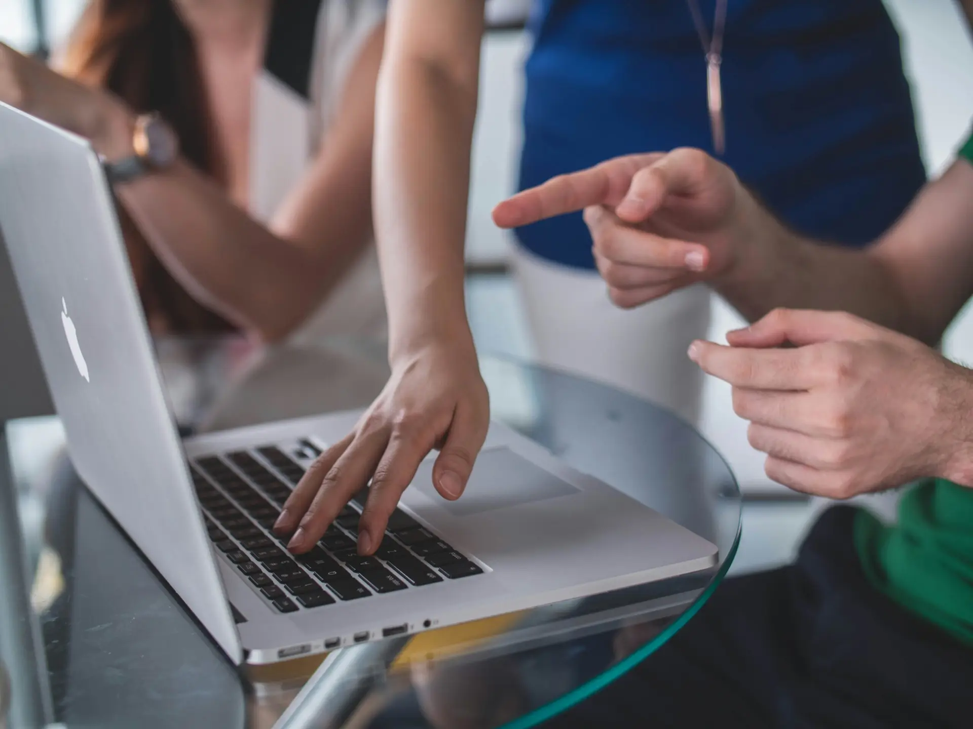 Team bespricht gemeinsam Inhalte auf einem Laptop