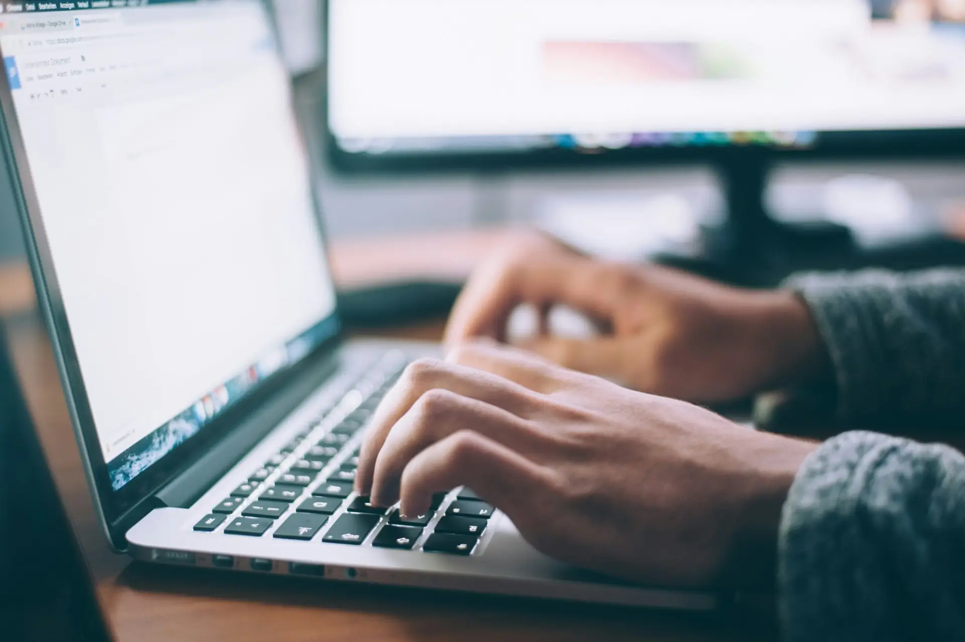 Person tippt einen Text auf einem Laptop