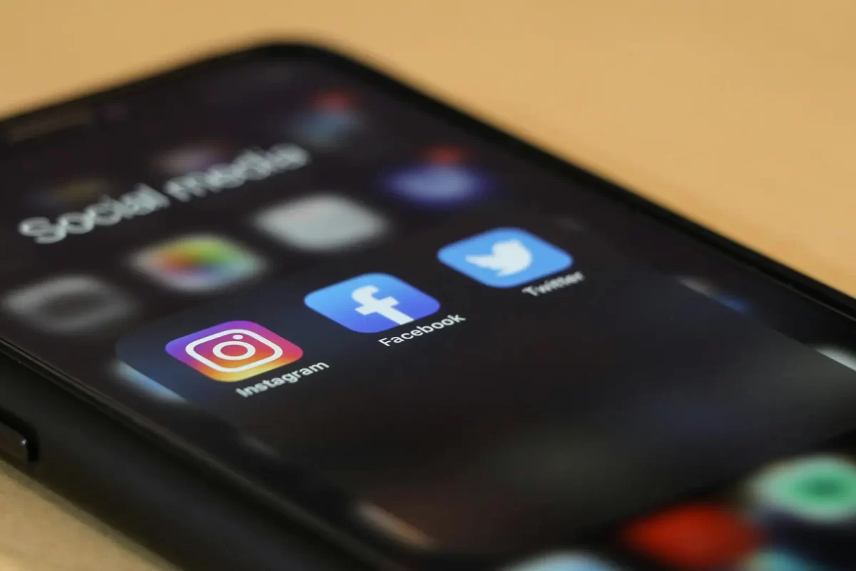 Dieses Bild zeigt ein Smartphone, auf dem ein App-Ordner mit den Apps von «Instagram», «Facebook» und «Twitter» (heute «X») geöffnet ist.