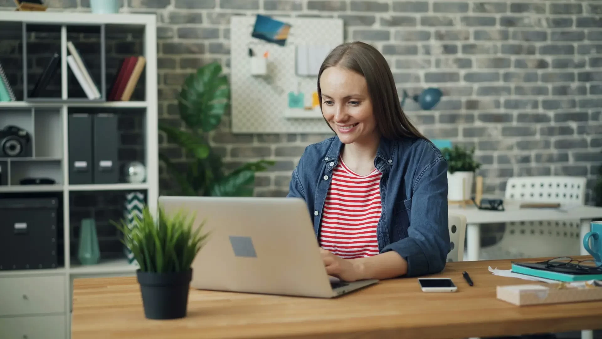 Symbolbild für das Thema «Profitabler werden.» Das Bild zeigt eine Geschäftsfrau, die glücklich auf ihren Laptop schaut.